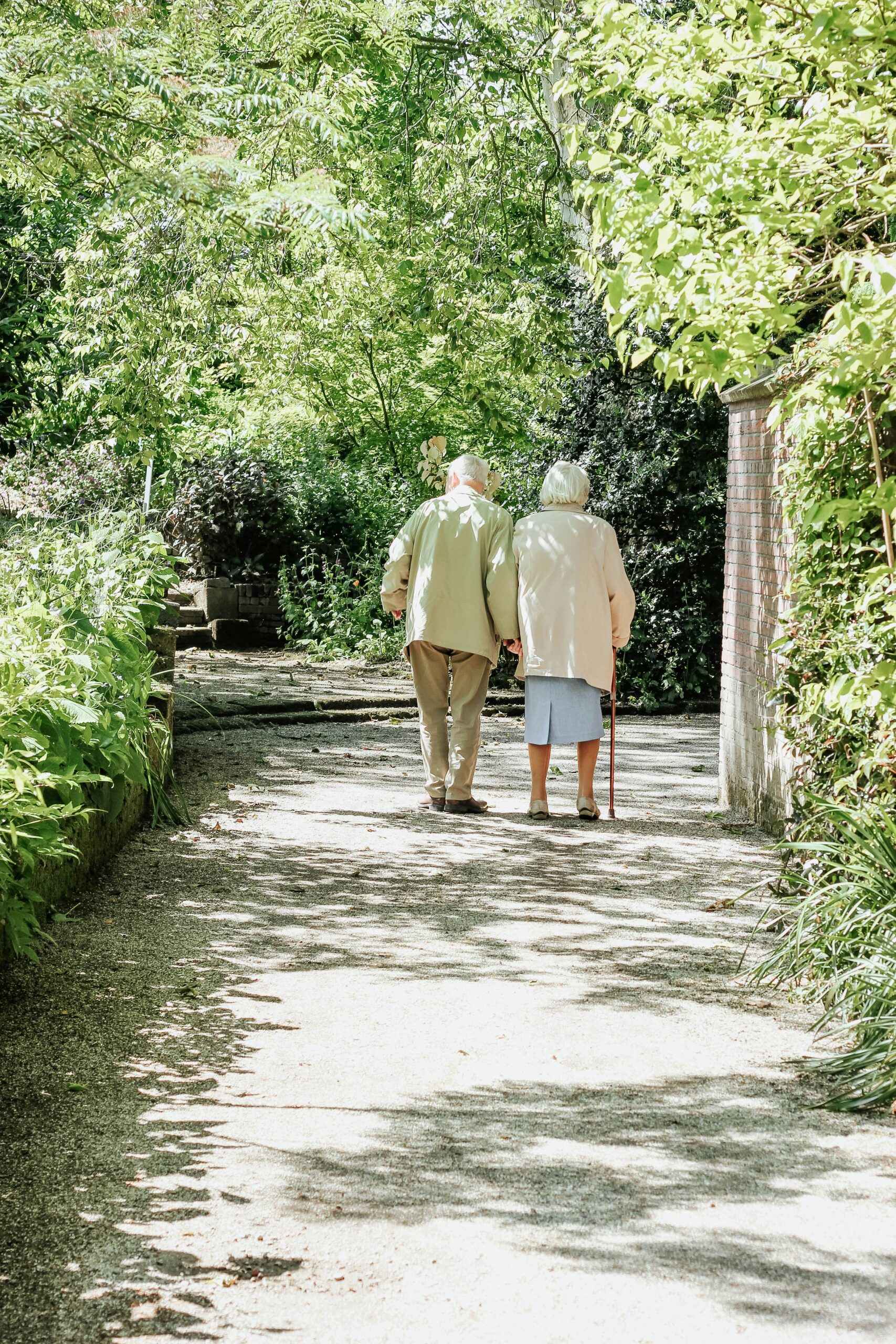 An elderly couple walking down a path together
